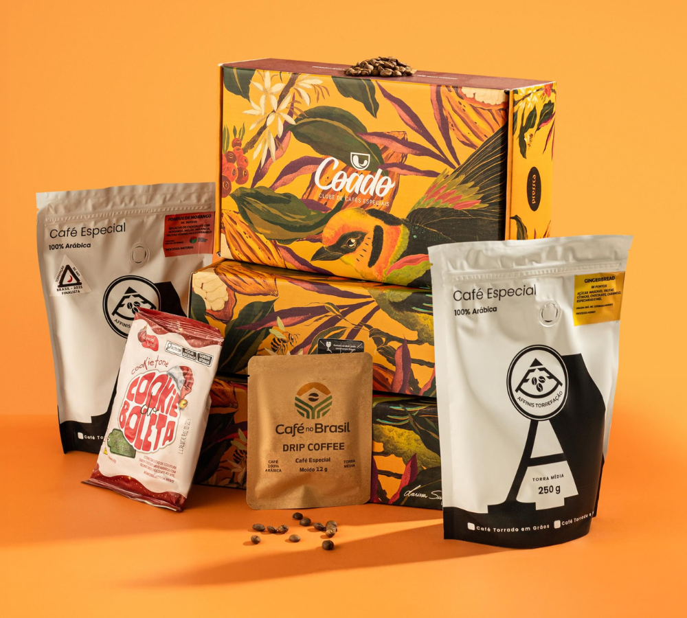 Box presente corporativa Coado com cafés especiais, cookies e drip coffee sobre fundo laranja